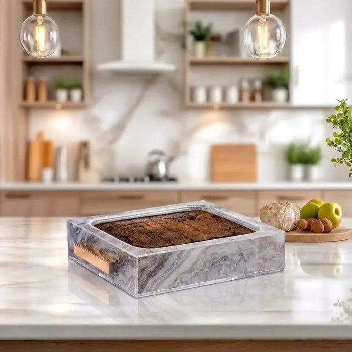 Agate 9x13 pan holder with gray marble-look finish displayed on kitchen counter, featuring copper handles and a brown interior tray.