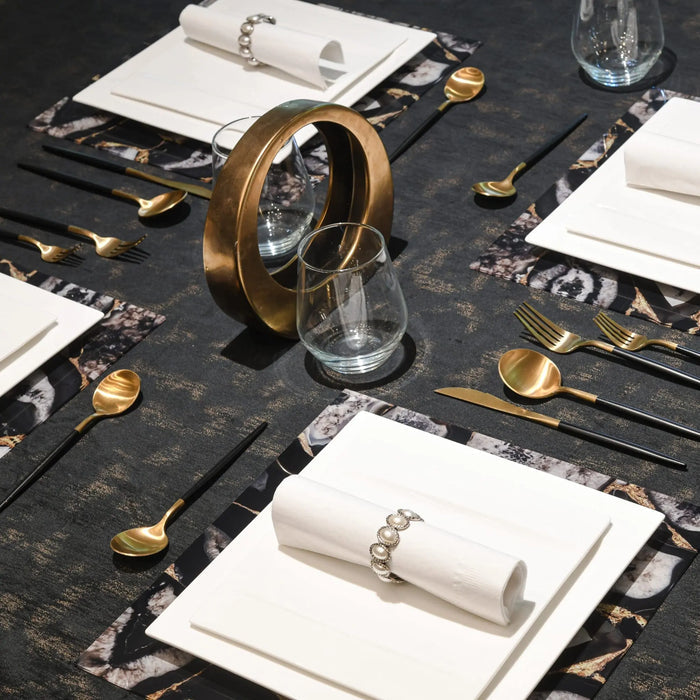 Black marble agate charger plate with gold accents, styled in an elegant table setting with gold flatware and white napkins.