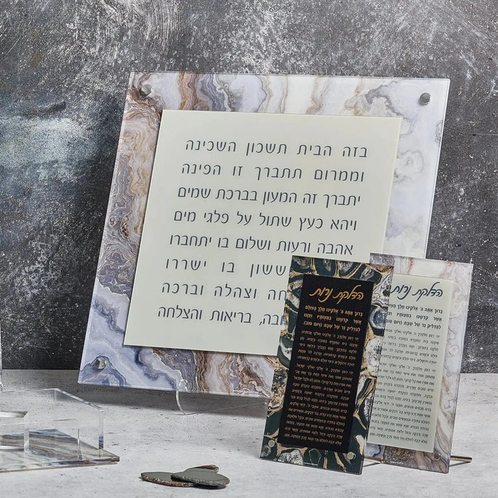 Agate tabletop plaque with Hebrew prayer text for Hadlokas Neiros Shabbat candle-lighting, displayed on marble surface with prayer book.