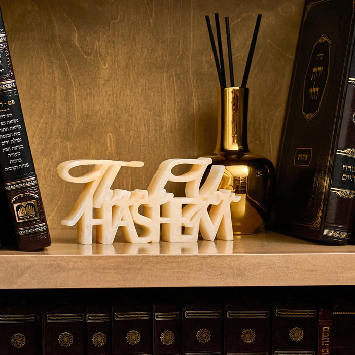Aura Vase Diffuser in cream ceramic with black reed sticks, displayed on wooden shelf with decor.