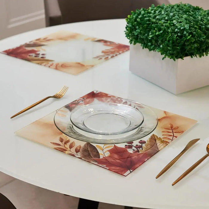 Autumn Chargers with fall leaf watercolor design in rust and gold tones, displayed with place setting on white round table with gold utensils.