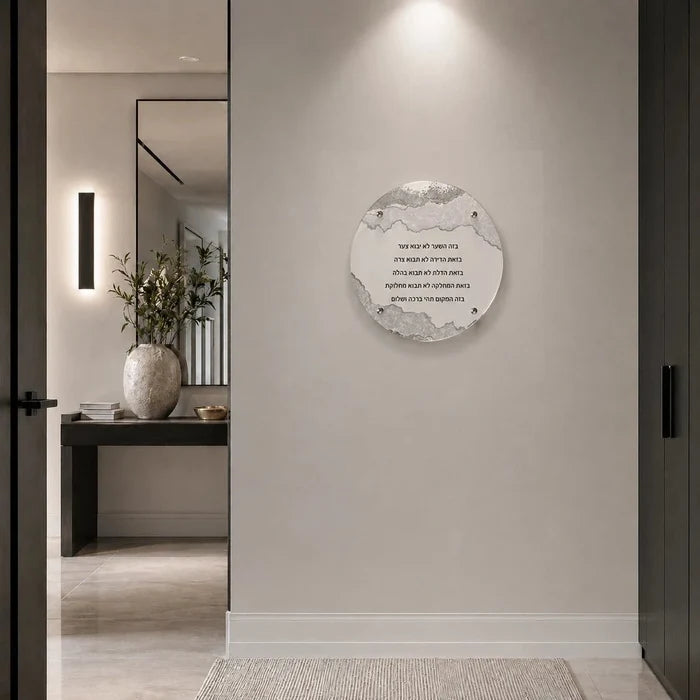 A circular wall art print featuring BIRCHAS HABAYIS displayed on a light beige wall in a modern, minimalist hallway with a mirror and console table visible in the background.