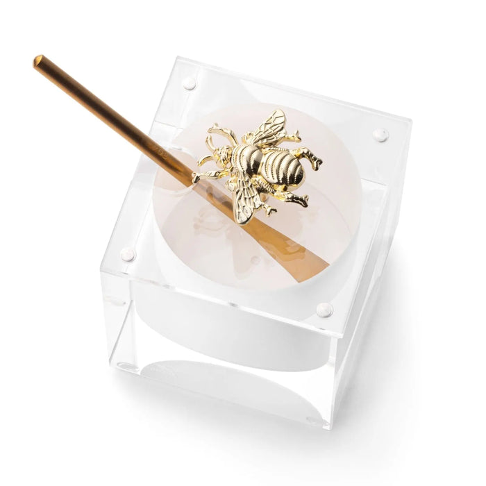 Gold bee honey dish in clear Lucite with a metal spoon for the Jewish New Year