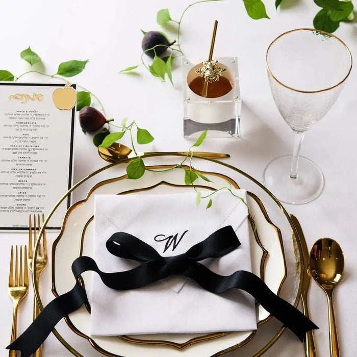 Bee honey dish with a gold spoon on a Rosh Hashonah place setting