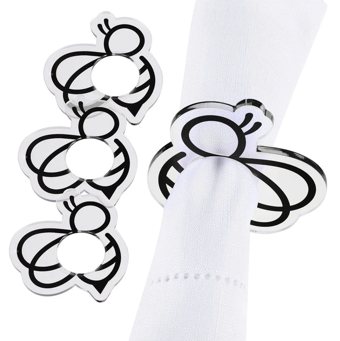 Set of four silver bee-shaped napkin rings on white napkin, perfect for holiday table settings and entertaining.