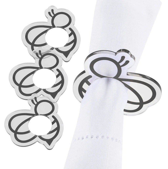 Set of four silver bee-shaped napkin rings holding white napkin on tabletop, detailed metallic design by Waterdale Collection.