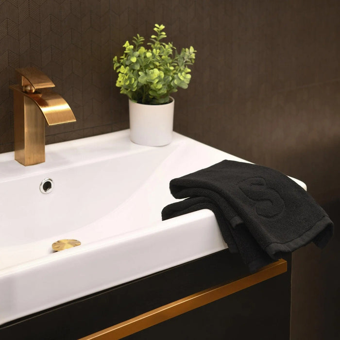 Black finger towel with embossed initial displayed on modern bathroom vanity sink, perfect for guest bathrooms and home decor.