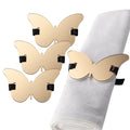 Butterfly napkin wraps in gold with black accents, displayed on a folded napkin for table setting decoration.