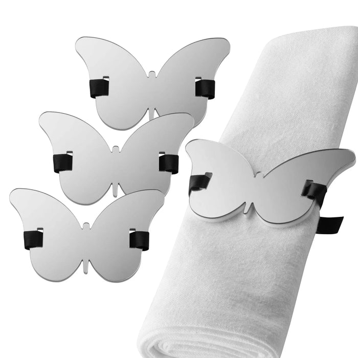 Silver butterfly napkin rings with black accents displayed on a white napkin, perfect for elegant table settings and formal dining occasions.