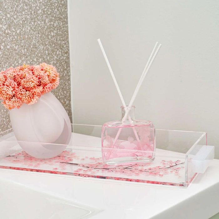 Cherry Blossom painted bread tray with pink floral design, displayed with white vase, pink flowers, and reed diffuser on marble surface.