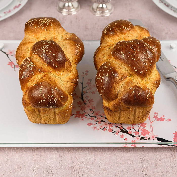 Cherry Blossom Challah Board by Waterdale Collection featuring twisted golden challah loaves on a ceramic tray with pink floral design.