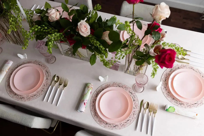 Cherry Blossom Chargers in blush pink displayed on a formal table setting with pink plates, silverware, and fresh floral centerpiece.