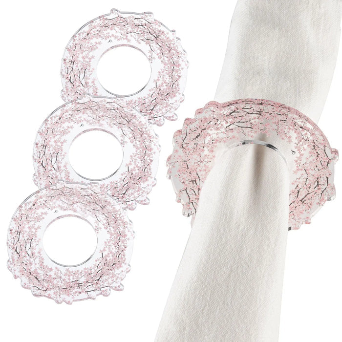 Three Cherry Blossom Napkin Rings in blush pink delicate wirework displayed on white napkins for elegant table settings.