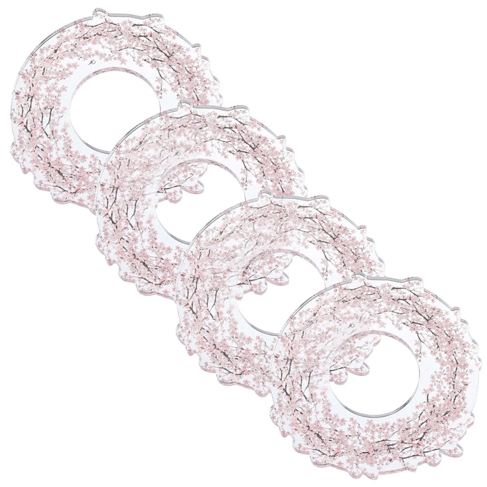 Four cherry blossom napkin rings with delicate pink floral details arranged in a diagonal line on white background.