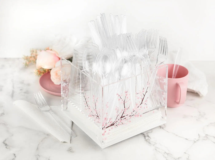 White marble silverware caddy with pink cherry blossom design and swivel base, displayed with fresh flowers and tabletop accessories on marble surface.