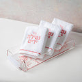 Cherry Blossom Towel Set by Waterdale Collection displayed in clear acrylic organizer with pink floral branding on white towel packaging.