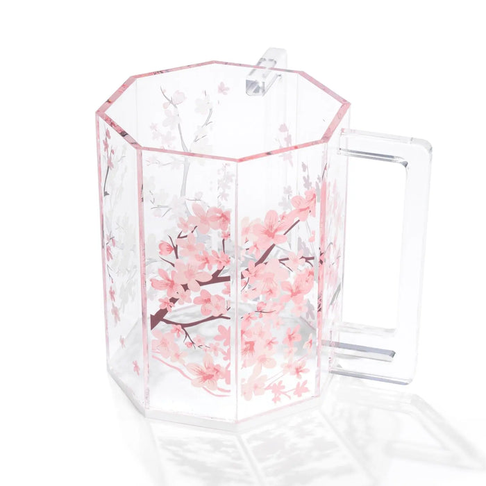 Cherry blossom washing cup with pink floral design on clear acrylic material, featuring a handle and measurement markings.