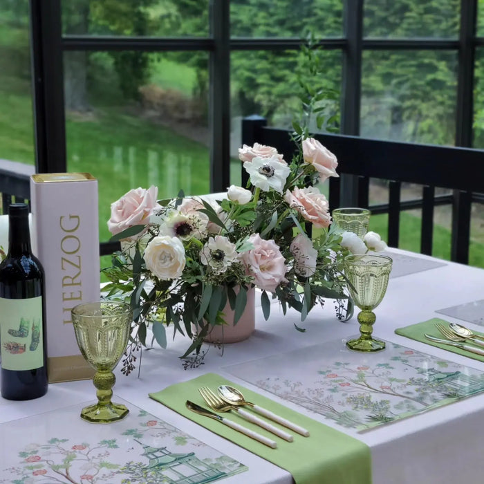 Waterdale Collection Chinoiserie Chargers in cream and green, featuring delicate floral motifs, displayed on table setting with flowers and wine.