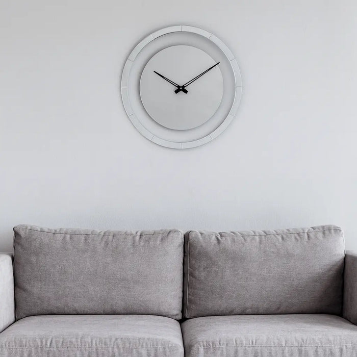 Minimalist circle wall clock with thin metal frame hanging above gray upholstered sofa in modern home interior