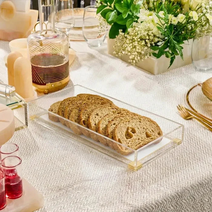 Classic 2.0 Basic bread tray in white ceramic displayed on a dining table with sliced bread, styled with place settings and floral centerpiece.