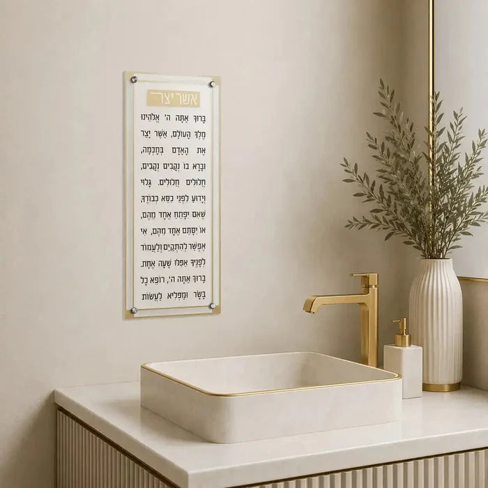 Classic 2.0 Basics Asher Yatzar wall art in black text with gold accents displayed above a white bathroom sink