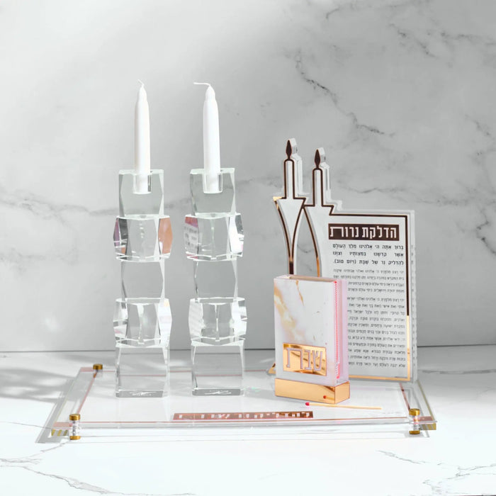 Marble matchbox holder with white candles and brass accents displayed on marble surface, designed for Shabbat candle lighting and home entertaining.