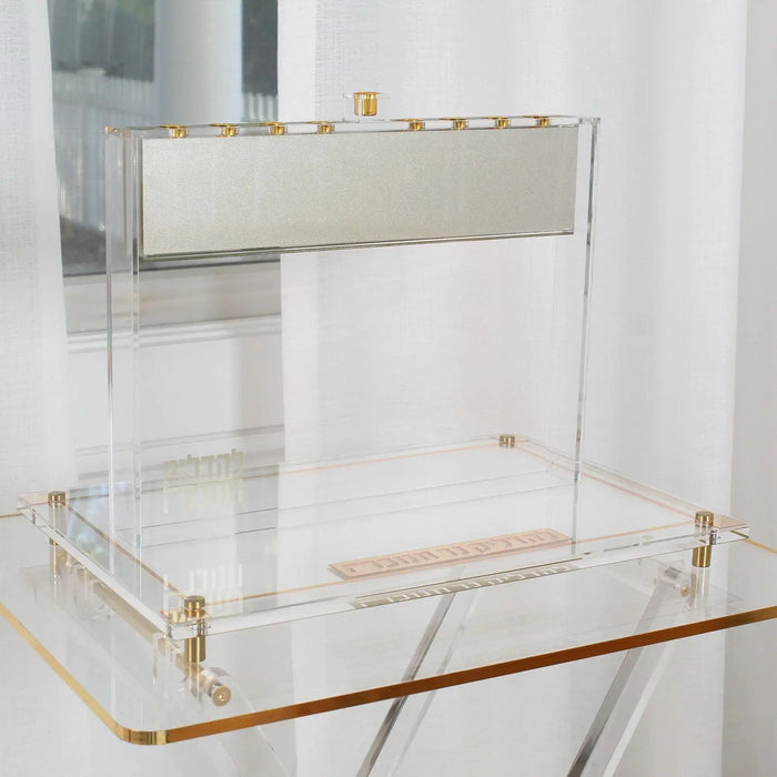 A silver Suspended Menorah standing on the Classic 2.0 Lucite menorah tray on a glass table, a Waterdale Collection Chanukah set-up