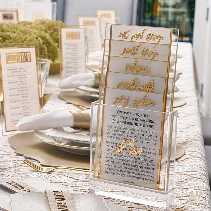 Classic 2.0 Shabbos card set in lucite displaying elegant gold text on translucent panels arranged on a white table setting