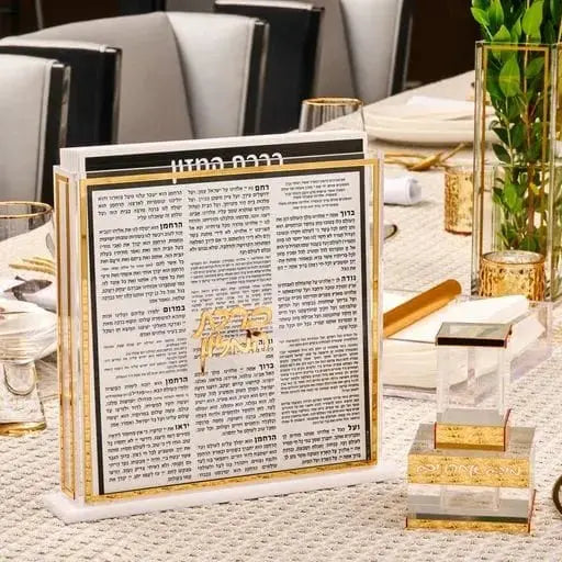 Classic Bencher Set with open prayer book displayed on wooden stand, surrounded by wine glasses and table settings for Shabbat