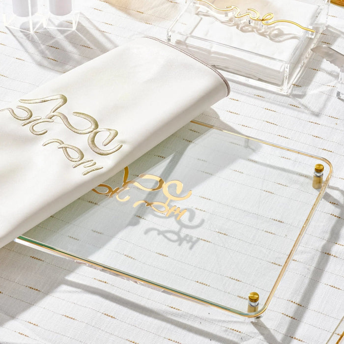 Classic white Challah Board with gold accents and handles, displayed with matching tabletop accessories and Shabbat serving pieces.