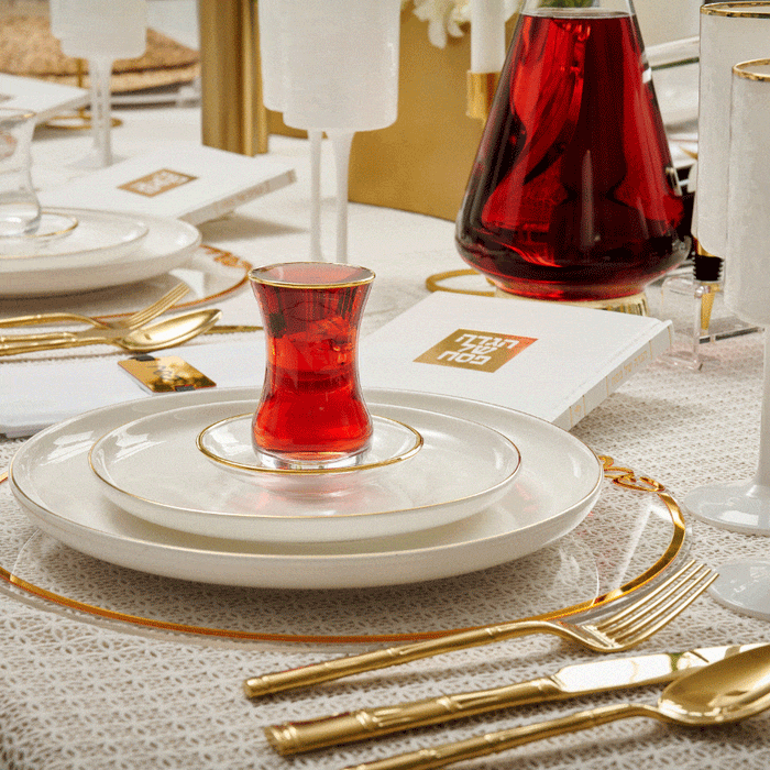 Classic Pesach Chargers by Waterdale Collection in silver, elegantly set on a formal dining table with gold utensils and red wine glasses.