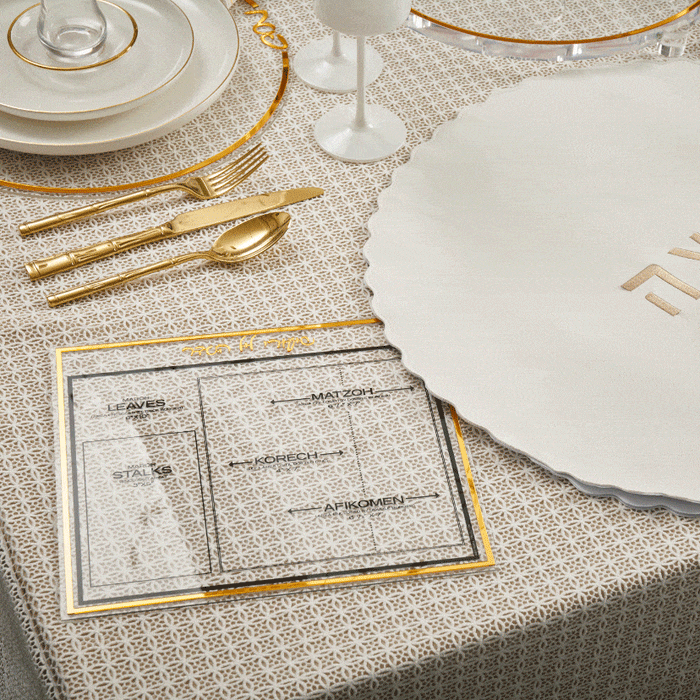 Waterdale Collection Classic Shiurim Card in gold and silver lucite, displayed on a place setting with white plates and napkins for Pesach table decor.