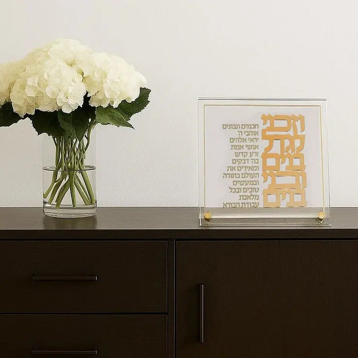 Classic Vezakeini Tabletop by Waterdale Collection featuring gold text design on cream background, displayed on dark shelf with white flowers