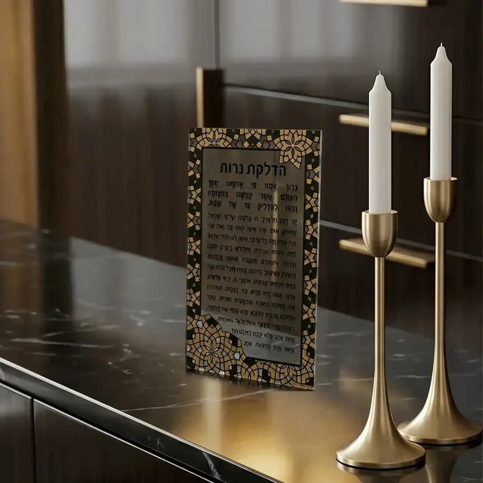 Clear acrylic Hadlokas Neiros card with decorative gold filigree border, displayed with white candlesticks on dark surface.