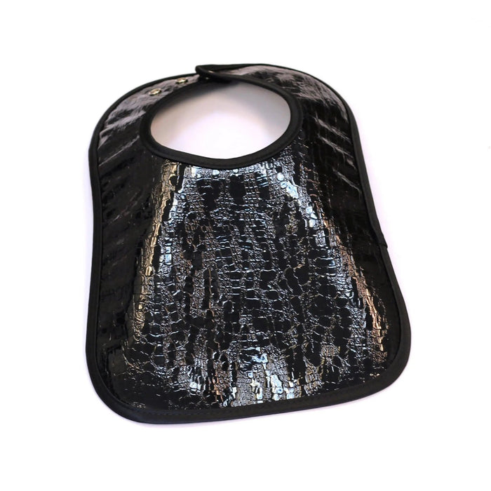 Black crocodile patent leather bib with textured embossed pattern and snap closure, designed for babies and toddlers by Waterdale Collection.