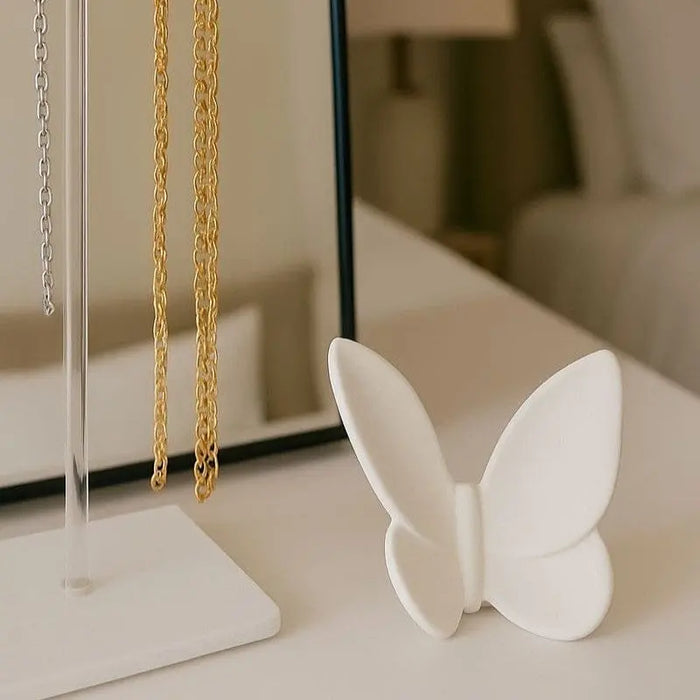 White crystal butterfly tabletop decoration with gold chain necklace displayed on stand