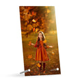 Custom tabletop print plaque featuring a child in a red dress standing in autumn foliage, displayed on a stand in warm golden tones.