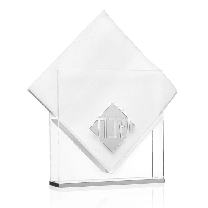 Diamond-shaped suspended napkin holder in white acrylic with geometric design, displayed on clear stand for Shabbat and holiday table settings.