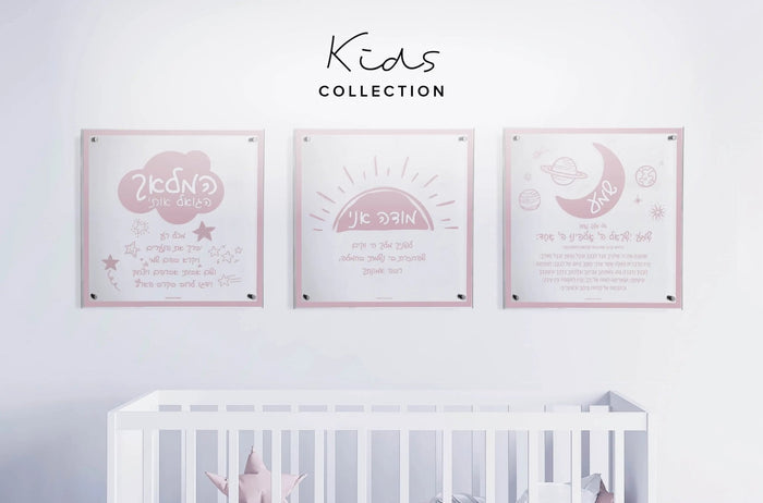 Three framed Doodle Hamalach wall art prints in soft pink tones displayed above a white crib in a nursery setting.