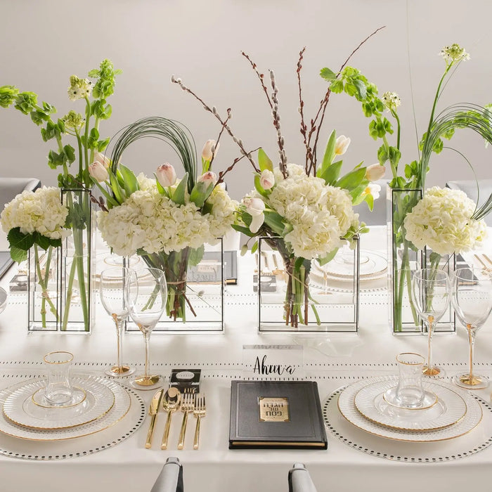 Clear glass double outline vase by Waterdale Collection displayed with white flowers and greenery in elegant table setting arrangement.