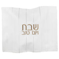 White linen challah cover with embroidered gold Hebrew text and vertical stitch details for Shabbat.