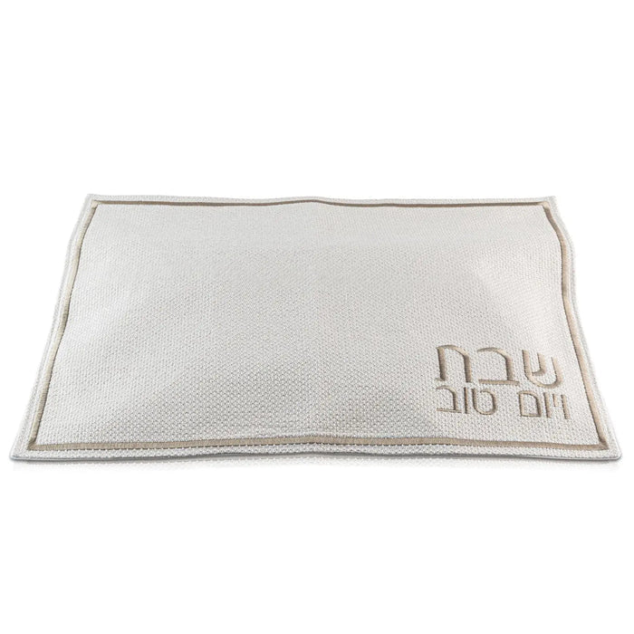 Cream and gold fabric challah cover with embroidered Hebrew text and silver trim, displayed flat on white background.