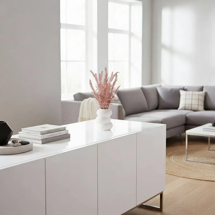 White faux floral donut vase by Waterdale Collection displayed on a modern console table in a bright living room setting.