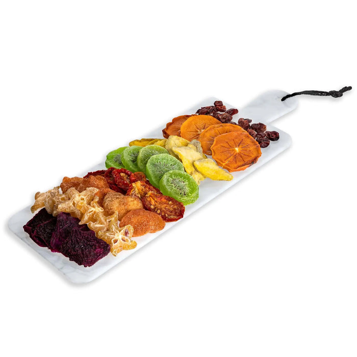 Flat marble charcuterie board displaying an assorted arrangement of colorful foods including cheeses, cured meats, fruits, and nuts on a white marble serving tray with black rope handle.