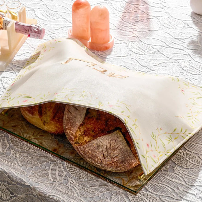 Floral Bird Challah Cover in cream leather with brown bird and floral design, displayed on challah bread for Shabbat.