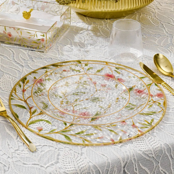 Floral Bird Charger plate with delicate pink and green botanical design on cream background, featuring gold rim and matching gold utensils on white damask tablecloth.