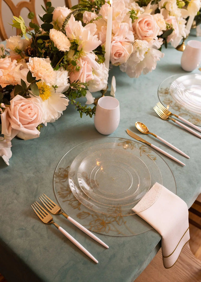 Waterdale Collection floral charger plate with delicate pink roses and greenery, displayed on a formal table setting with gold cutlery and pale pink napkin.