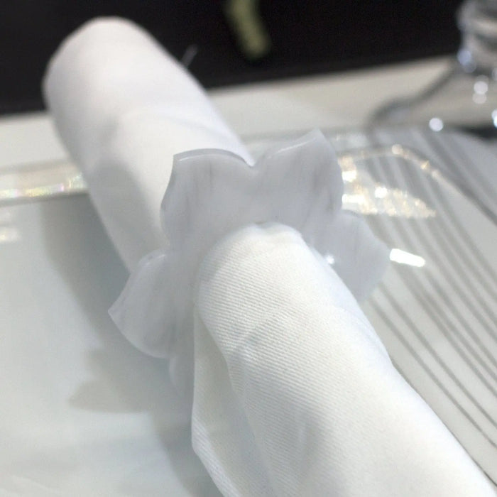 Marble Lucite napkin ring in a flower shape, with a white rolled napkin inside.