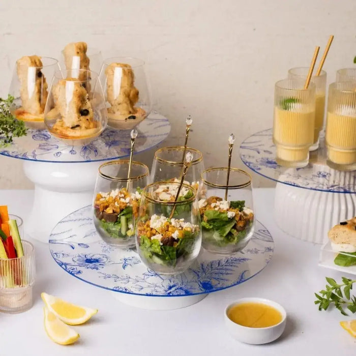 French Toile Chargers in blue and white with elegant floral pattern, displayed with appetizers and beverages in a table setting.