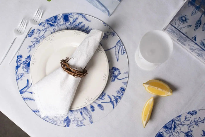 French Toile Charger plate in blue and white with traditional pattern, styled with napkin and tableware for formal dining.
